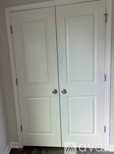 Two white doors with silver handles.