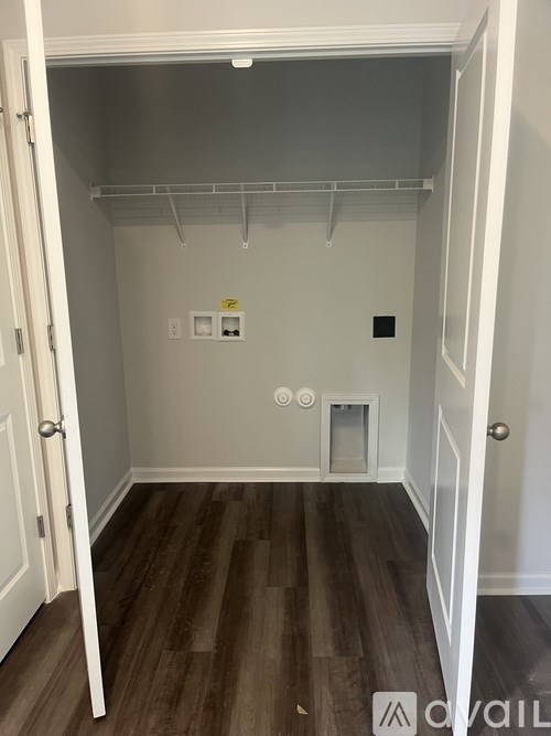A small, empty closet with a white door and a small white shelf.