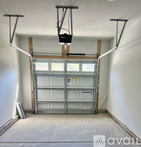 A garage door is being lifted by a metal frame and a pulley system.