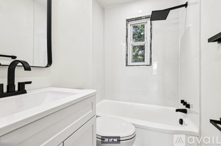 A white bathroom with a toilet, sink, and bathtub.