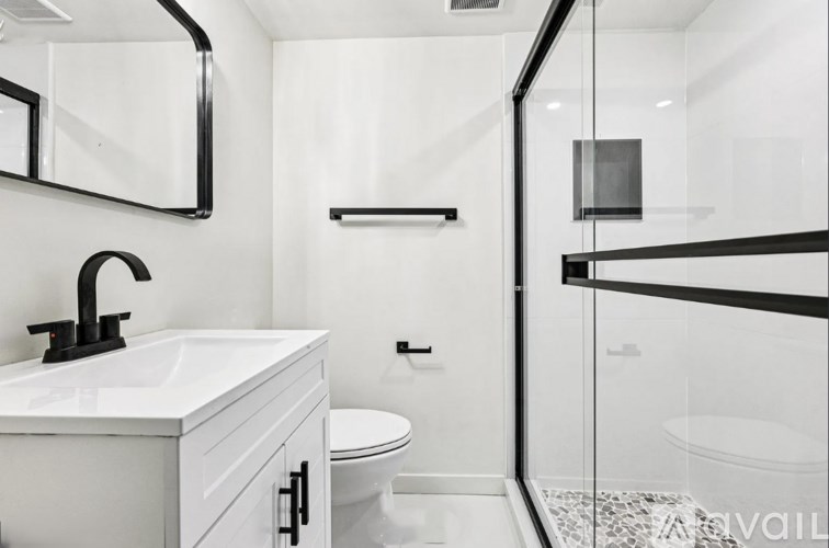 A bathroom with a white sink and toilet.