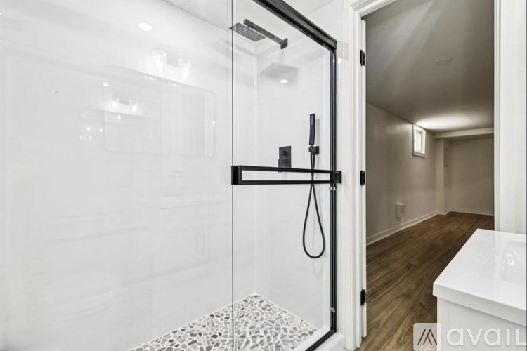 A bathroom with a glass shower door and a white bathtub.