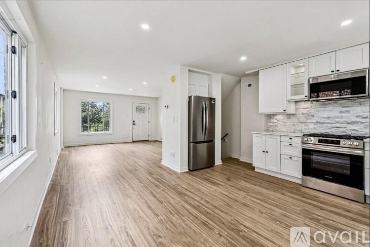 A spacious kitchen with wooden flooring and stainless steel appliances.