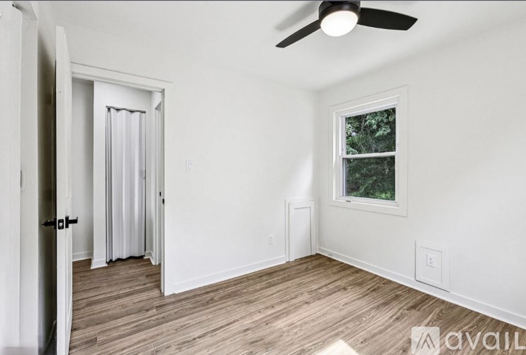 A room with a ceiling fan and a window.