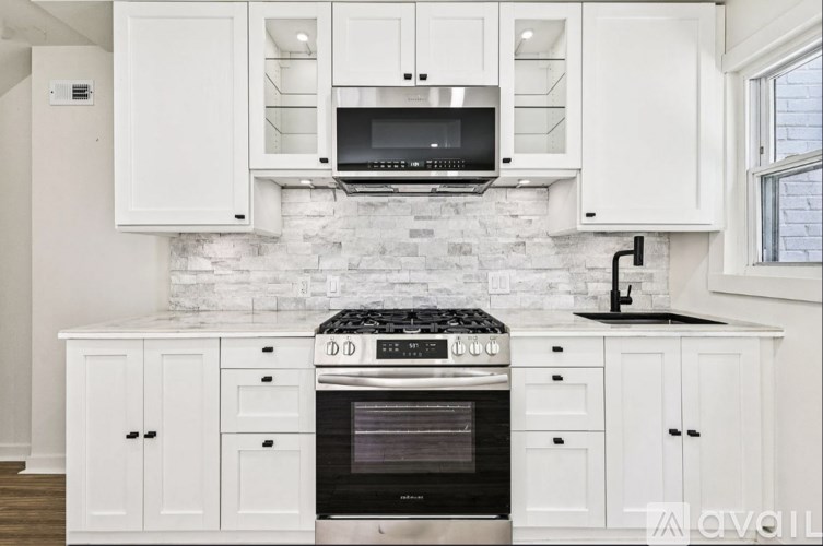 A kitchen with white cabinets and a black stove top oven.