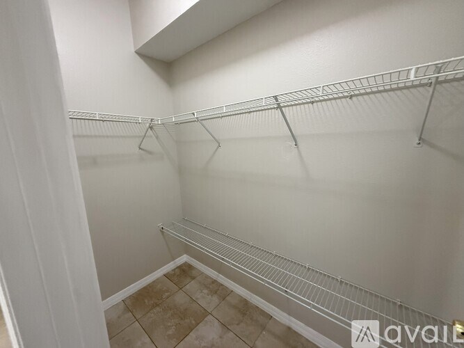 A walk-in closet with white walls and a tiled floor.
