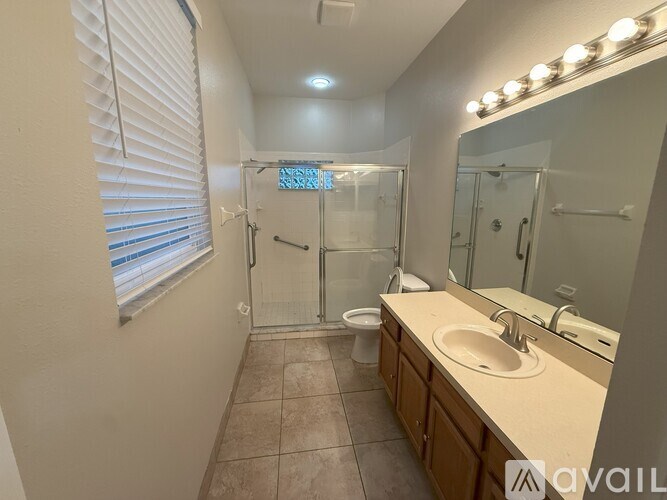 A bathroom with a sink, mirror, and shower.