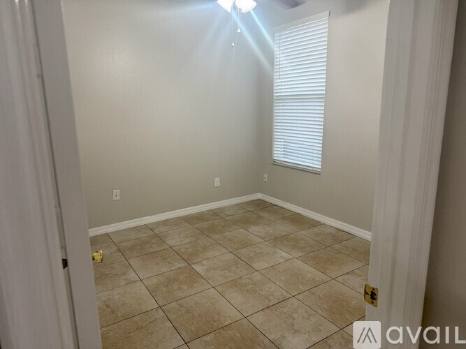 A room with beige tiled flooring and white walls.