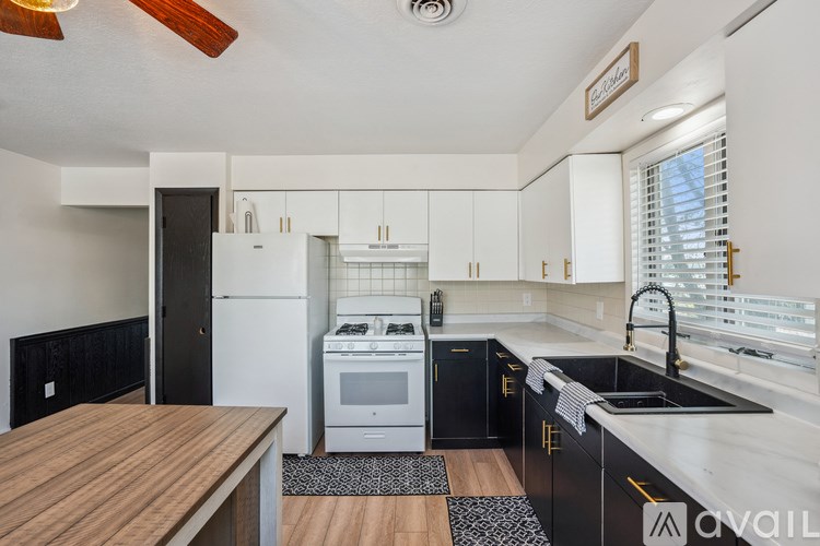 A kitchen with black cabinets and a wooden table.