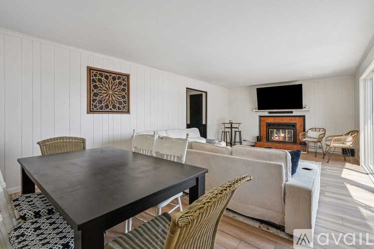 A living room with a fireplace and a dining table.