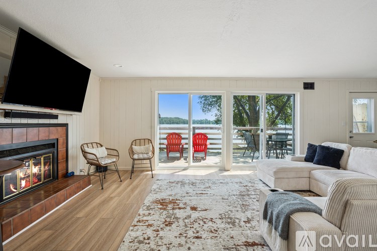 A living room with a fireplace and a television on the wall.