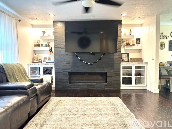 A living room with a fireplace and a flat screen TV mounted above it.