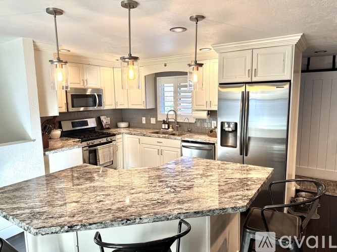 A kitchen with granite countertops and stainless steel appliances.