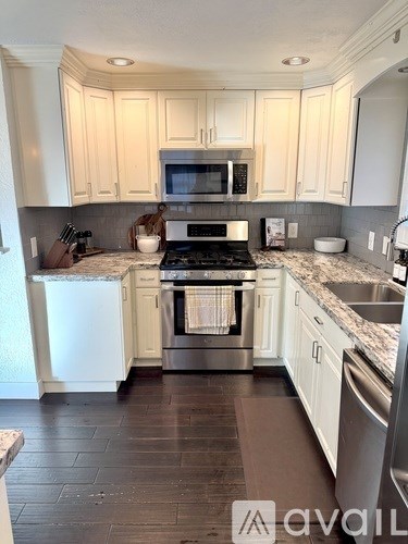A kitchen with white cabinets and a black stove top.