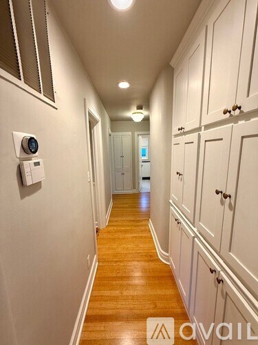 A long hallway with wooden floors and white walls.