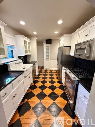 A kitchen with black and white checkered flooring.