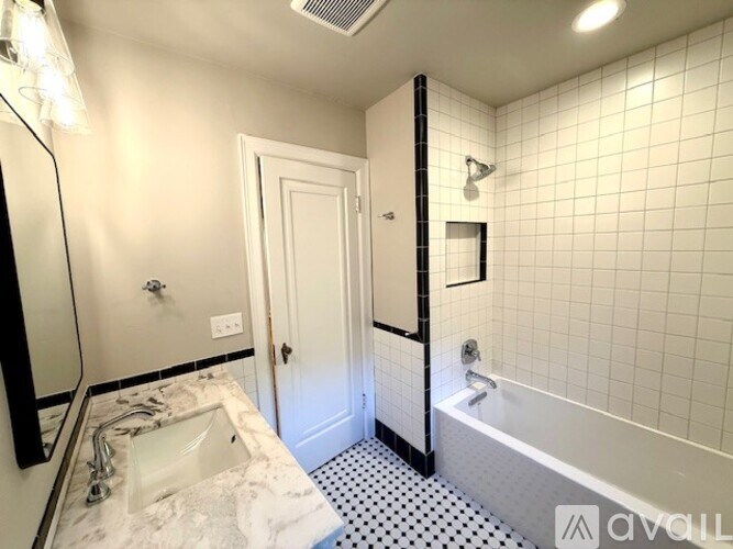 A bathroom with a white sink and a white bathtub.