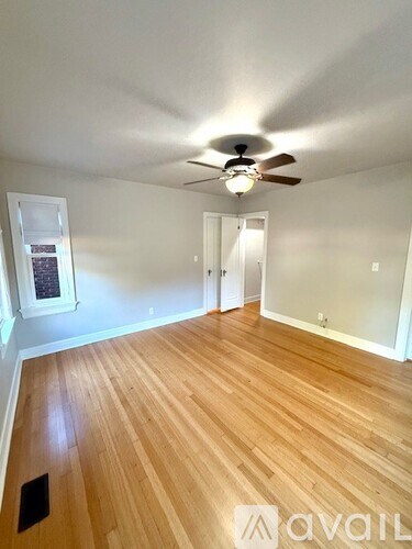 A room with wooden flooring and a ceiling fan.