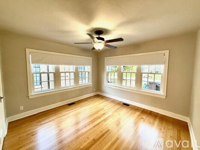 A room with wooden floors and a ceiling fan.