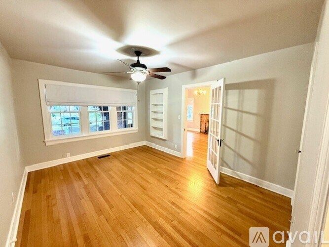 A room with wooden floors and a ceiling fan.