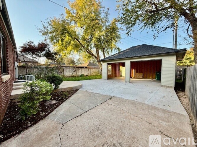 A house with a driveway and a tree in front of it.
