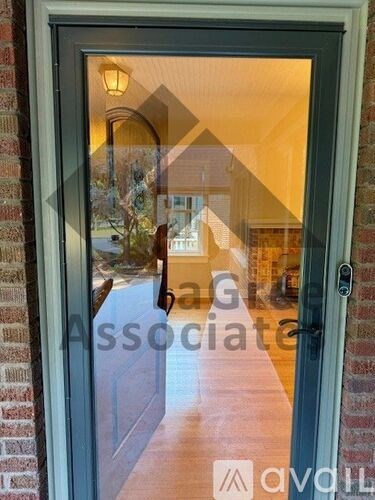 A glass door with a reflection of a house and trees.
