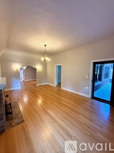 A room with wooden flooring and a chandelier.
