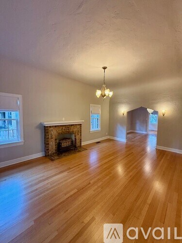 A room with a fireplace and wooden floors.
