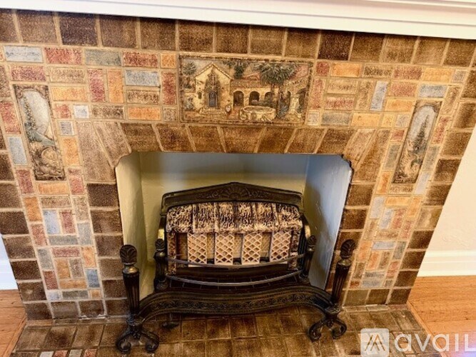 A fireplace with a mosaic tile wall above it.