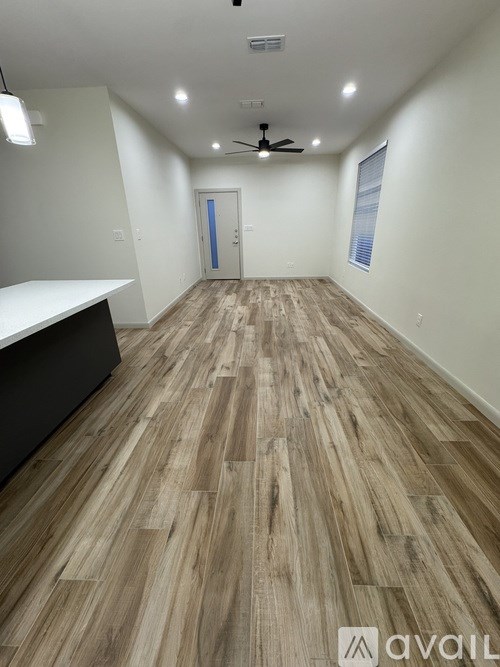 A room with wooden flooring and a ceiling fan.