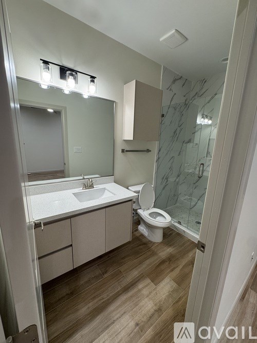 A bathroom with a sink, toilet, and mirror.
