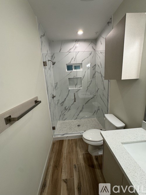 A bathroom with a marble shower and toilet.