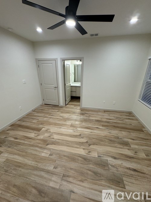 A room with wooden flooring and a ceiling fan.