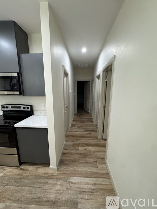 A long hallway with a kitchen area on the left side.