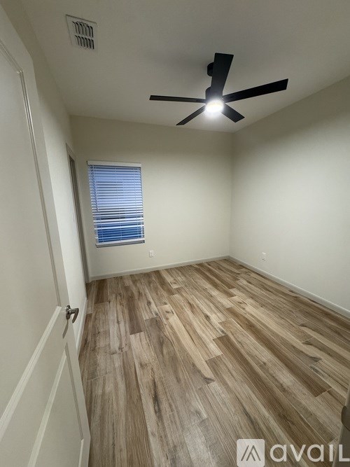 A room with wooden flooring and a ceiling fan.