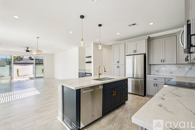 A modern kitchen with a marble countertop and stainless steel appliances.