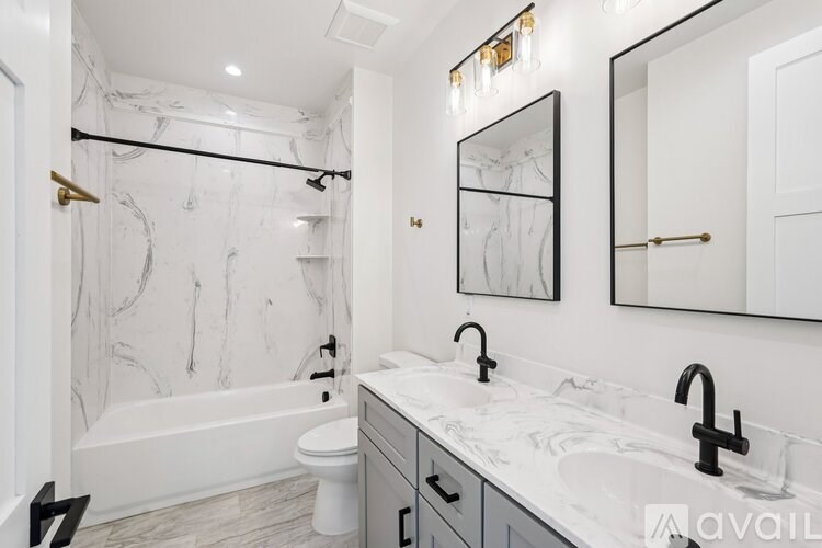 A bathroom with a marble patterned wallpaper and a white bathtub.