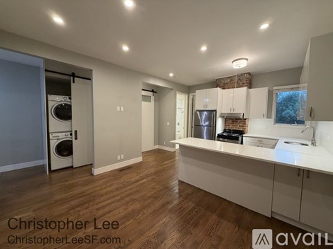A modern kitchen with wooden floors and white countertops.