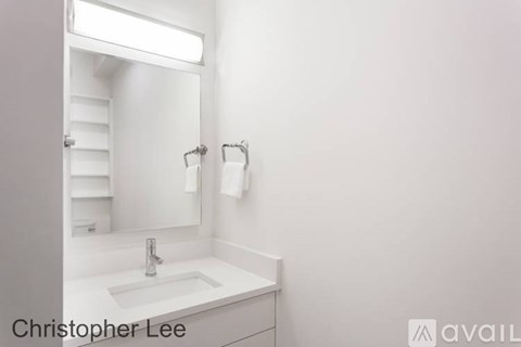 A bathroom with a sink, mirror, and light.