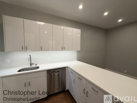 A kitchen with white cabinets and a sink.