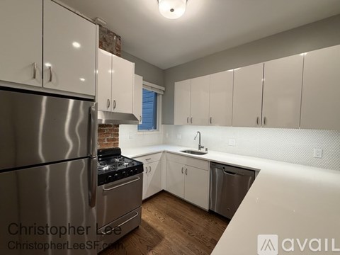 A kitchen with white cabinets and a stainless steel refrigerator.