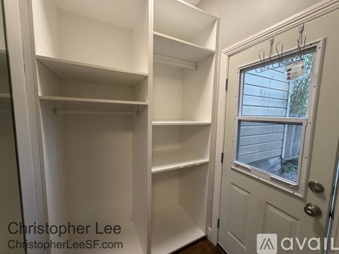 A white closet with shelves and a door with a window.