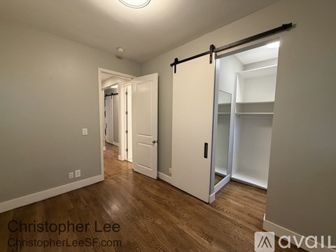 A room with a sliding door and wooden floors.