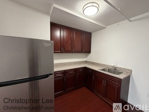 A kitchen with brown cabinets and a stainless steel refrigerator.