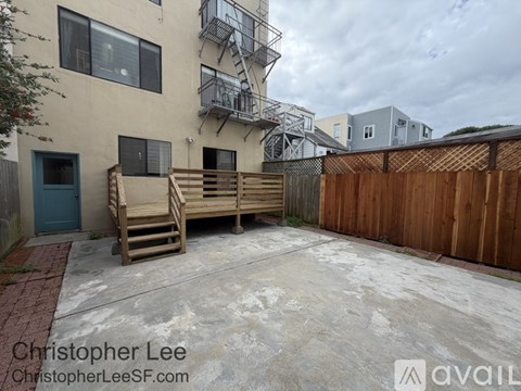A patio with a wooden bench and a metal fire escape.