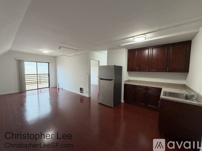 A kitchen with dark wood cabinets and a stainless steel refrigerator.