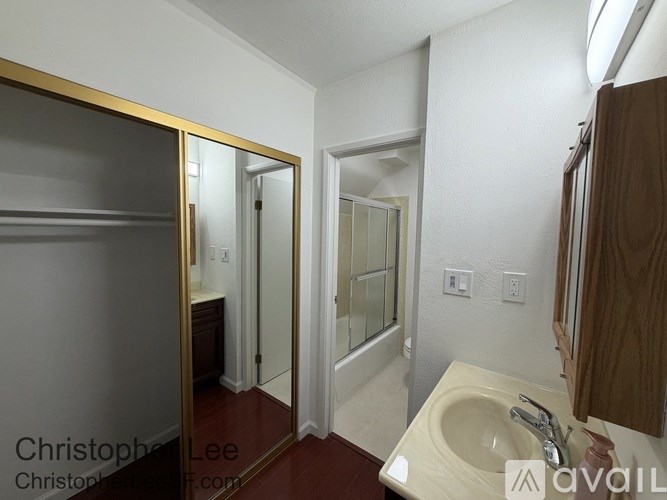 A bathroom with a sink, mirror, and shower.