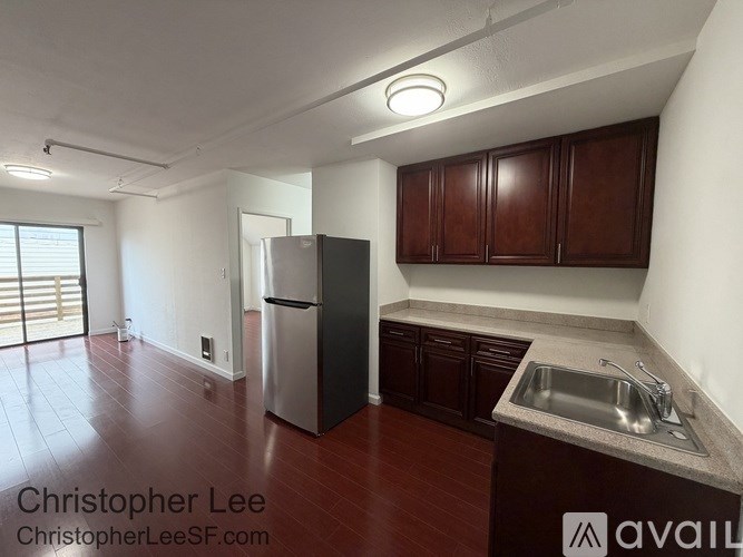 A kitchen with dark wood cabinets and a stainless steel refrigerator.