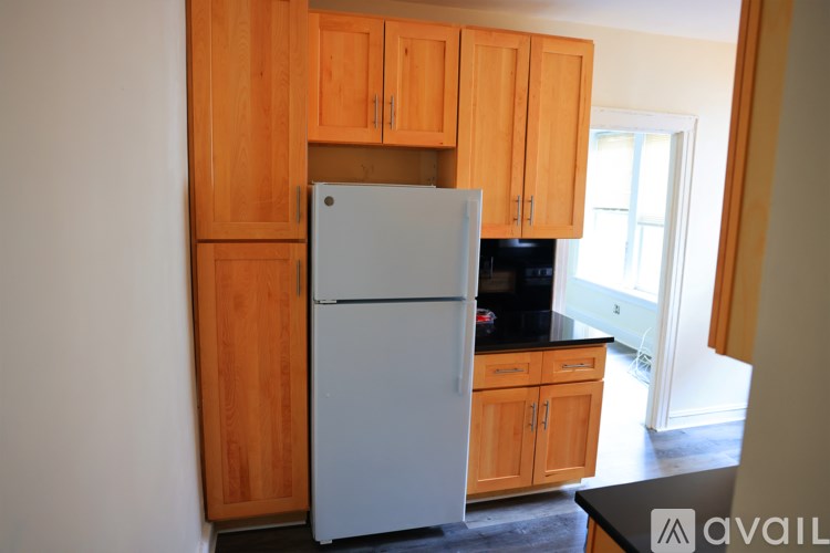 A kitchen with wooden cabinets and a white refrigerator.