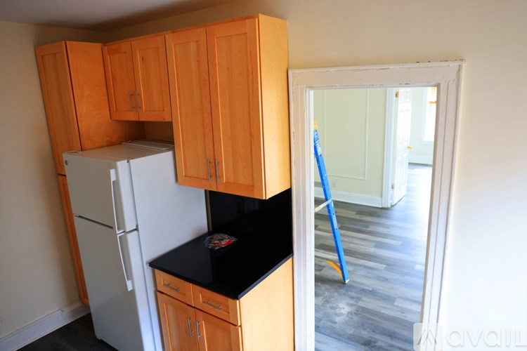 A kitchen with wooden cabinets and a black countertop.